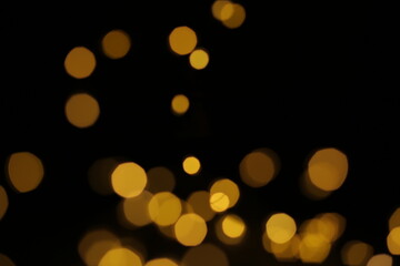 lights from a garland on a black background. Christmas yellow lights. Texture of lights for...