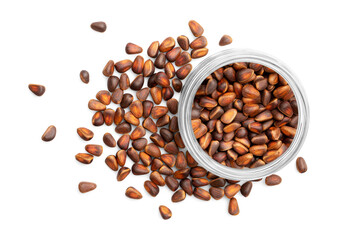 Glass bowl with pine nuts in shell isolated on white background. Top view, close up.