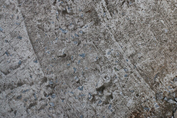 Black cracked concrete texture interspersed with small blue stones. Background.