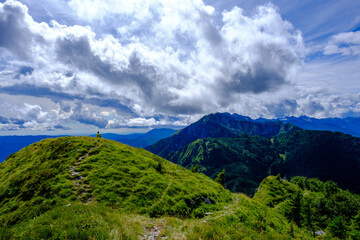 Fototapeta premium Donna seduta sulla cima di una montagna guarda la vallata, Mozic, Slovenia