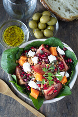 Lentil salad with pumpkin, tomatoes, pomegranate seeds, spinach and goat cheese. Refreshing legume and vegetable salad. Vegetarian food photography
