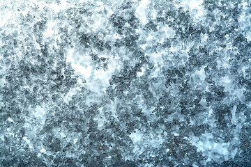 Close-up snow texture on the window with a beautiful gradient in blue and light blue tones.
