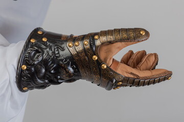 Medieval knightly brown plate gauntlet from Italian armor, in the form of a lion's face and mane,...