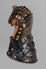 Medieval knightly brown plate gauntlet from Italian armor, in the form of a lion's face and mane,...