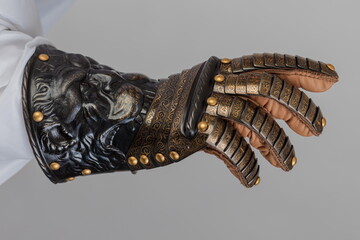 Medieval knightly brown plate gauntlet from Italian armor, in the form of a lion's face and mane,...