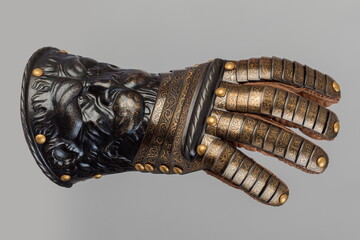 Medieval knightly brown plate gauntlet from Italian armor, in the form of a lion's face and mane,...