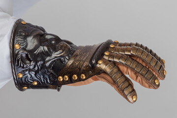 Medieval knightly brown plate gauntlet from Italian armor, in the form of a lion's face and mane,...