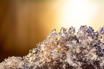 The texture of natural snow in the sun at sunset. Macro texture of snow.