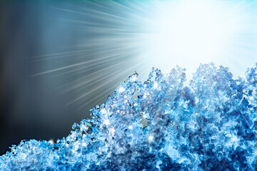 Natural snow texture with bright rays of the sun and sun glare. Close-up texture of snow on the window in soft blue tones. Creative winter festive background.