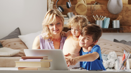 Happy family at home, mother with son and daughter have fun using computer, parent with children...
