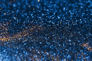 Blue and golden sparkling glitter bokeh background, christmas abstract defocused texture. Holiday...