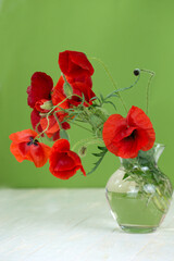 Bouquet of red poppy flowers in glass vase
