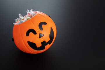 Fototapeta premium halloween sale, pumpkin candy bowl with lollipops,copy space,black background