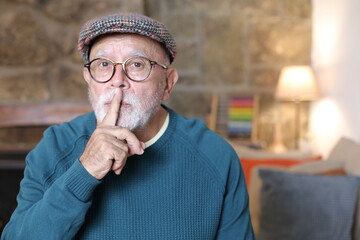 Elder man bringing finger to lips