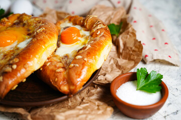 Georgian cheese pastry selective focus on center. Khachapuri, flour pie stuffed with cottage cheese, eggs. National Georgian dish. Oven baked dough