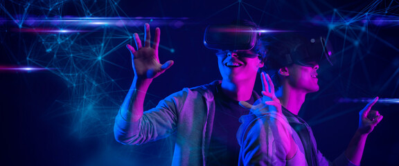 Teenager having fun play VR virtual reality glasses Esport game futuristic neon colorful...