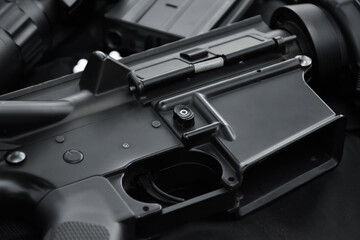 Airsoft gun with round white plastic bullets on a black leather background.
