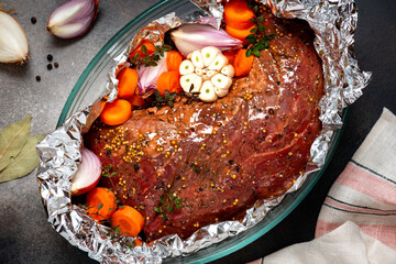 Meat with vegetables is baked in foil. Raw beef, vegetables, spices and herbs are wrapped in foil...