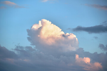 Bright landscape of white puffy cumulus clouds on blue clear sky.