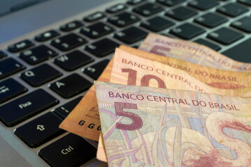 brazilian money on computer keyboard. 5 reais