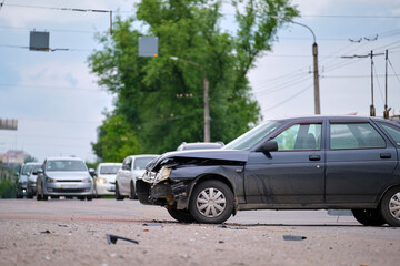 Damaged in car accident vehicle on city street crash site.