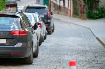 City traffic with cars parked in line on street side.