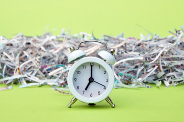 A white vintage clock in the foreground of 7:00 am on a light green background.