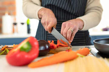 Close up of senior caucasian woman in kitchen wearing apron cooking