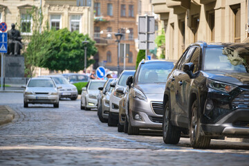 City traffic with cars parked in line on street side.