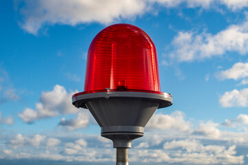 Red signal lamp against the blue sky.