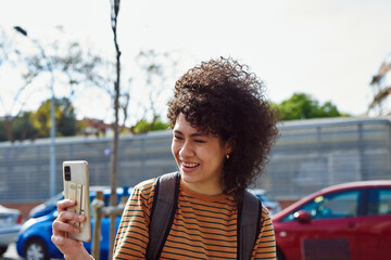 Smiling young woman having a video call outdoors