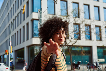 Cheerful young woman extending her arm forward