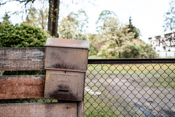 Old rusty metal mailbox on a wooden fence (1037)