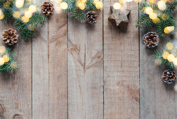 Christmas background with fir tree branches, pine cones, and Christmas lights