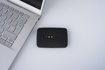 Pocket  wireless or internet. Mobile Wifi device near laptop or notebook on isolated white...