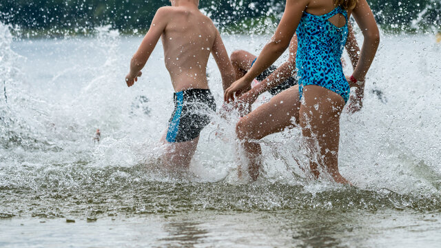 Cutout Of Children Running Into A Lake During A Kids Triathlon Competition