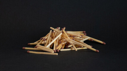 mountain of unlit matches on black background