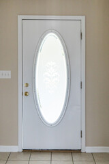 The interior inside view of a 1980's white front door with an oval filled with frosted decorative glass and it is ready for a refresh or renovation