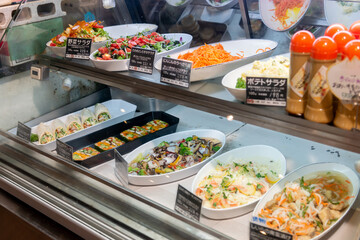 スーパーマーケットの食品売り場のショーケースに並ぶ惣菜
