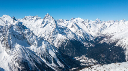 Plakat Caucasus Mountains, Panoramic view of the ski slope with the mountains Belalakaya, Sofrudzhu and Sulakhat on the horizon in winter day. Dombai ski resort, Western Caucasus, Karachai-Cherkess, Russia.