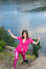 portrait of a fashionable beautiful young girl in pink, generation z. Against the background of the lake water