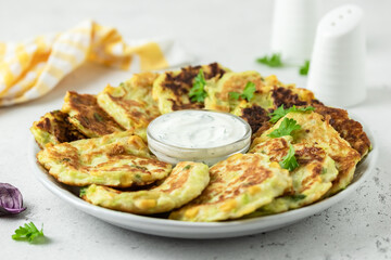 Vegetarian  zucchini corn fritters with yogurt garlic and dill sauce. Space for text.