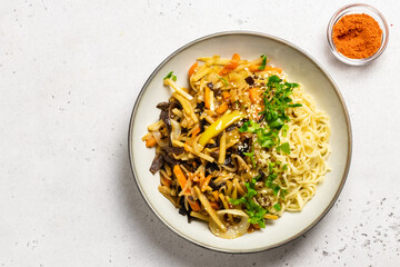 Asian stir fry vegetables noodles in a bowl. Top view, copy space.