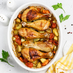 Lemon garlic roast chicken legs with vegetables in baking dish. Top view, copy space.