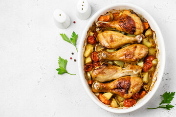 Ginger orange roast chicken legs with vegetables in baking dish. Top view, copy space.