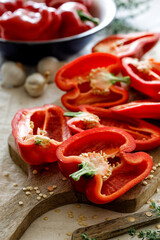 Fresh red peppers cut in halves on a board, close up view