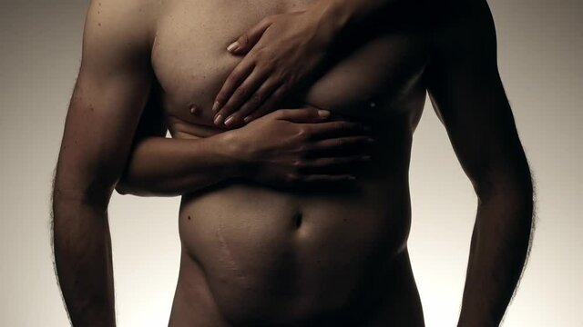 Female hands slowly touching torso with abs of male