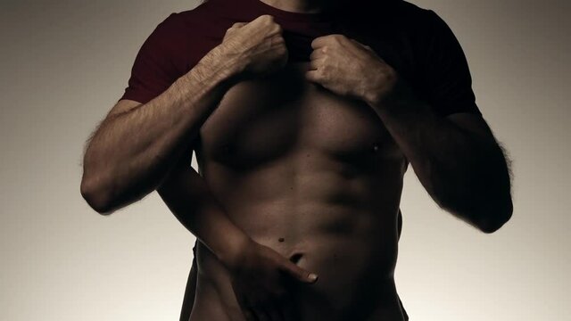 Female hands slowly touching torso with abs of male