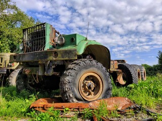 Obraz premium old rusty truck stands in the field. flat tire. old mechanism