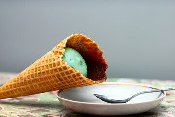 Beautiful fresh big sweet aromatic appetizing natural green cold ice cream in crispy waffle cone,...